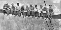 Intrepid steel workers atop the 70 story RCA building in Rockefeller Center get all the air and freedom they want by lunching on a steel beam with a sheer drop of over 800 feet to the street level. Image taken on September 20, 1932. <br>