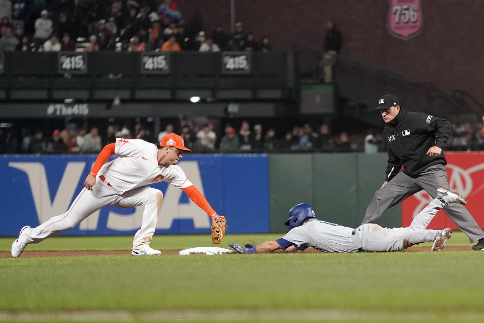 Los Angeles Dodgers' Austin Barnes, bottom right, slides into second base after hitting an RBI double next to San Francisco Giants second baseman Wilmer Flores during the eighth inning of a baseball game in San Francisco, Tuesday, Aug. 2, 2022. (AP Photo/Jeff Chiu)