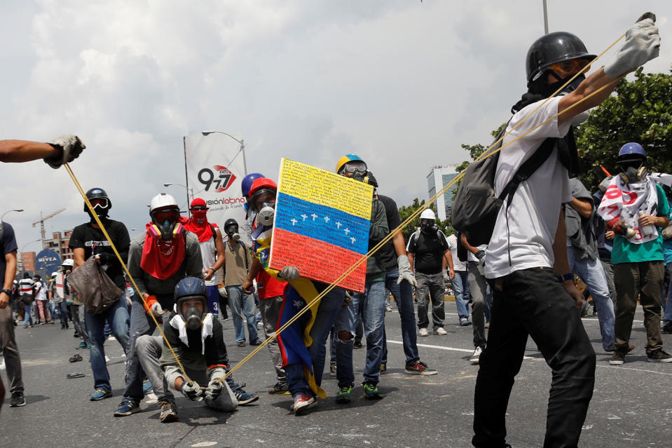 <p>Opposition supporters uses a giant sling shot to throw a “Poopootovs”, a bottle filled with feces, which is a play on Molotov, during a rally against President Nicolas Maduro in Caracas, Venezuela, May 10, 2017. (Photo: Carlos Garcia Rawlins/Reuters) </p>