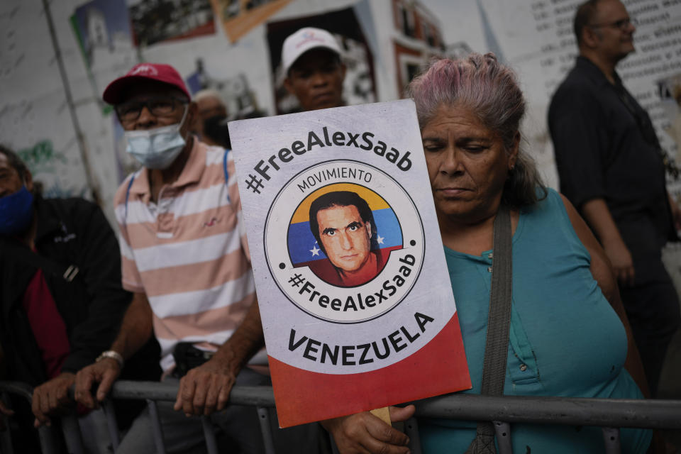 A woman holds a poster showing Colombian-born businessman Alex Saab in a demonstration demanding his release, in Caracas, Venezuela, Friday, Dec. 16, 2022. For more than two years, almost since the time of his arrest on U.S. warrant, Saab has insisted he is a Venezuelan diplomat targeted for his work helping the South American country circumvent American economic sanctions. (AP Photo/Matias Delacroix)