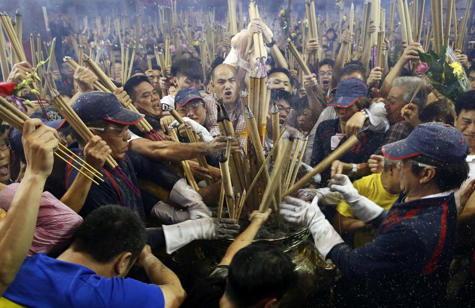 People rush to plant the first joss stick of the Lunar New Year at the stroke of midnight at the Kwan Im Thong Hood Cho temple in Singapore