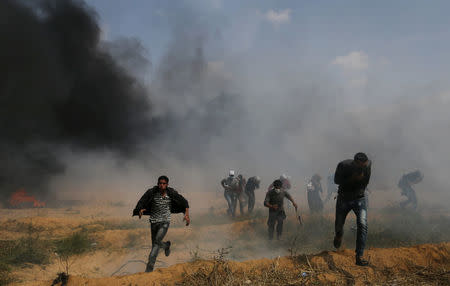 Palestinian demonstrators run for cover during clashes with Israeli troops at a protest demanding the right to return to their homeland, at the Israel-Gaza border in the southern Gaza Strip, April 27, 2018. REUTERS/Ibraheem Abu Mustafa