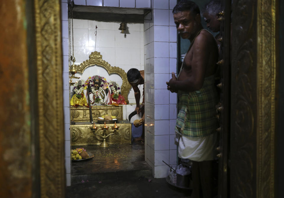 A Hindu priest prepares to break a coconut to offer to a deity during special prayers for U.S. Vice President-elect Kamala Harris ahead of her inauguration, at a temple in Thulasendrapuram, the hometown of Harris' maternal grandfather, south of Chennai, Tamil Nadu state, India, Wednesday, Jan. 20, 2021. A tiny, lush-green Indian village surrounded by rice paddy fields was beaming with joy Wednesday hours before its descendant, Kamala Harris, takes her oath of office and becomes the U.S. vice president. (AP Photo/Aijaz Rahi)