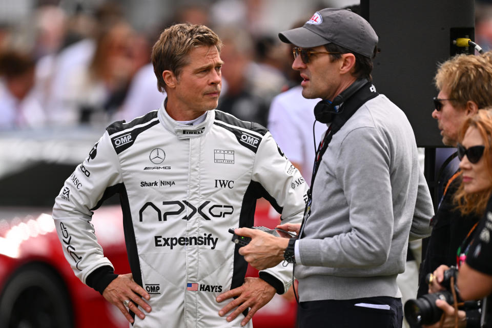 NORTHAMPTON, ENGLAND - JULY 09: Brad Pitt, star of the upcoming Formula One based movie, Apex, and Joseph Kosinski, director of the upcoming Formula One based movie, Apex, talk on the grid during the F1 Grand Prix of Great Britain at Silverstone Circuit on July 09, 2023 in Northampton, England. (Photo by Dan Mullan/Getty Images)