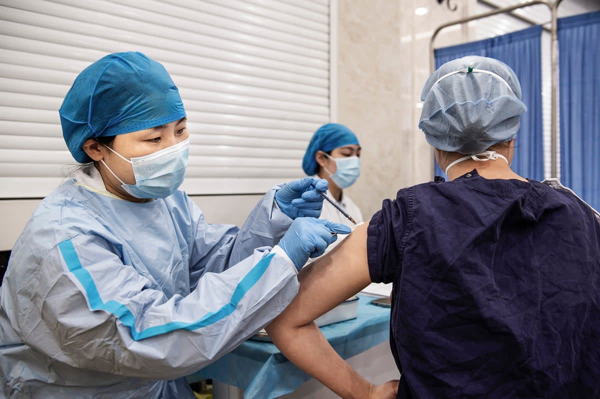 A woman receives a booster shot of the Sinopharm Covid-19 coronavirus vaccine at a hospital in Wuhan  (AFP via Getty Images)