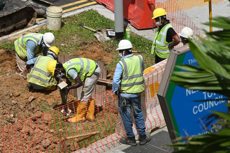 Migrant workers take part in repair work next to a road in Singapore on 3 June 3, 2020. (PHOTO: AFP via Getty Images)