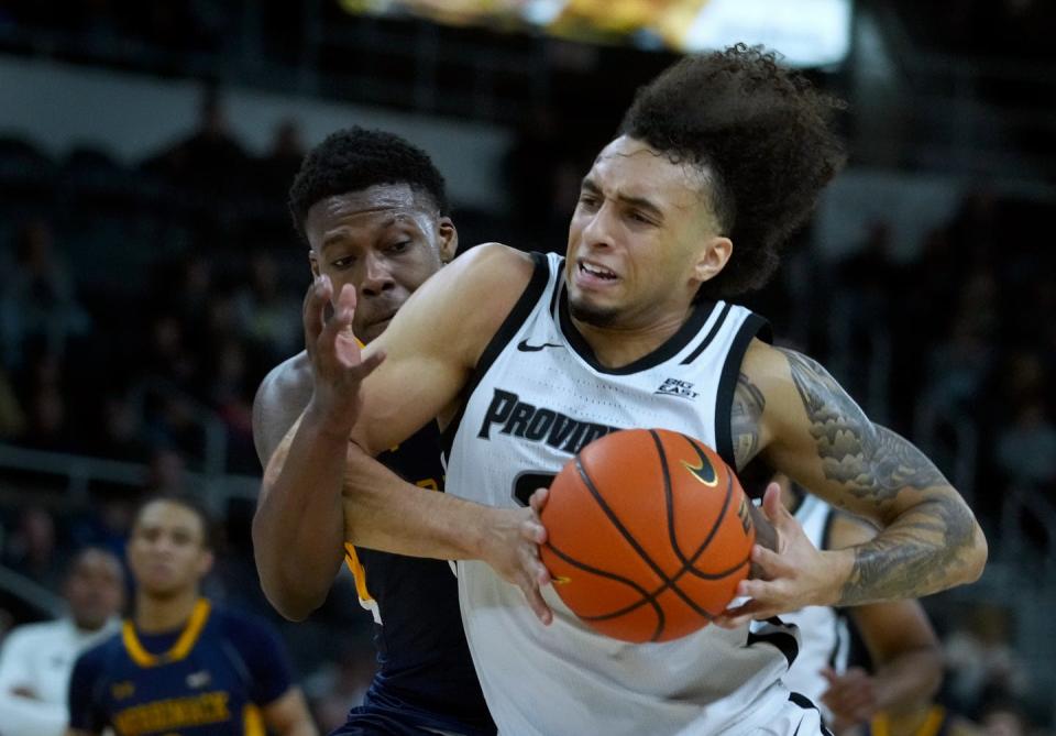 Providence Friars guard Devin Carter drives to the PC hoop  against Merrimack defender Devon Savage after scooping up a loose ball in the first half. 