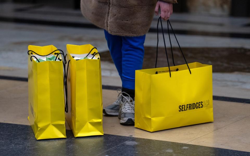 A woman waits with shopping bags outside a department store on January 20, 2023 in London, United Kingdom - Getty Images Europe