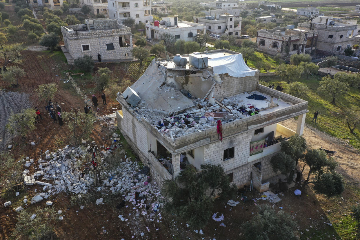 People inspect a destroyed house following an operation by the U.S. military in the Syrian village of Atmeh, in Idlib province, Syria, Thursday, Feb. 3, 2022. U.S. special operations forces conducted a large-scale counterterrorism raid in northwestern Syria overnight Thursday, in what the Pentagon said was a "successful mission." Residents and activists reported multiple deaths including civilians from the attack. (AP Photo/Ghaith Alsayed)