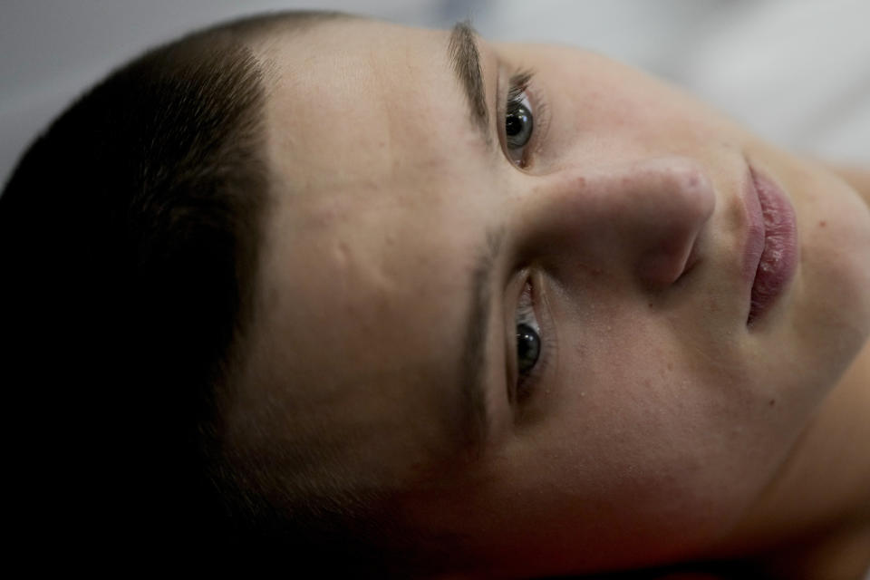 "Buffalo," the name he uses as a soldier, lies on a bed at a clinic in Kyiv, Ukraine, Friday, June 17, 2022. A series of clandestine, against-the-odds, high-speed helicopter missions to reach the Azovstal defenders in March and April — some of them ending in death — are being celebrated in Ukraine as one of the riskiest, most heroic feats of military derring-do of the four-month war. Buffalo owes them his life — the life he had hoped would end quickly, to end his torment, after exploding 120mm mortar rounds tore apart his left leg, bloodied his right foot, and peppered his back with shrapnel during street fighting in Mariupol. (AP Photo/Natacha Pisarenko)