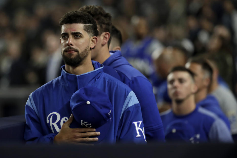 Kansas City Royals players listen to "God Bless America" during the seventh-inning stretch of the team's baseball game against the New York Yankees, Thursday, April 18, 2019, in New York. The Yankees have suspended the use of Kate Smith's recording of "God Bless America" while they investigate an allegation of racism against the singer. The New York Daily News reported there are conflicting claims about Smith's 1939 song "That's Why Darkies Were Born." The song originated in the 1931 Broadway review "George White's Scandals," and was considered satire. It was recorded by Smith and by Paul Robeson, who was black. (AP Photo/Julio Cortez)