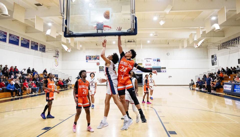 Modesto Christian’s Marcus Washington scores past Cosumnes Oaks’ Kendall Brown during the Sac-Joaquin Section Division I playoff game at Modesto Christian High School in Salida, Calif., Wednesday, Feb. 14, 2024.