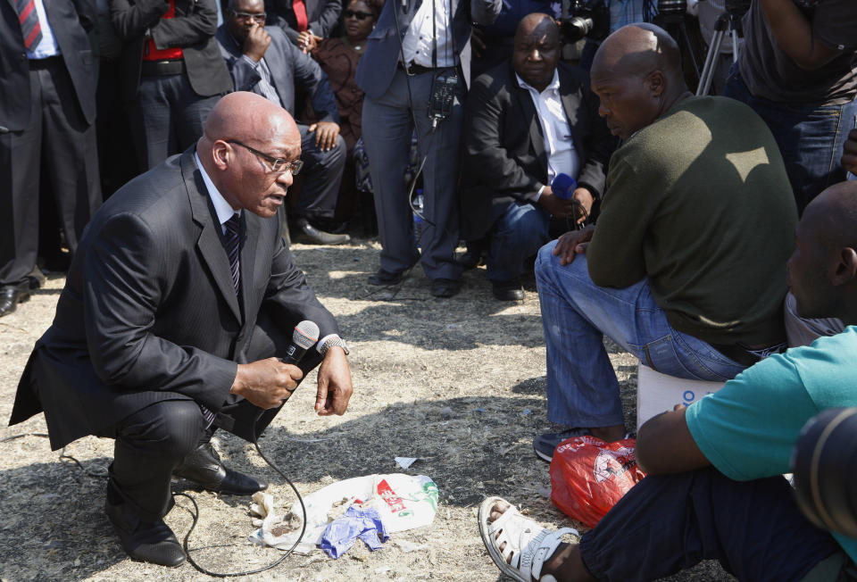 South Africa's President Jacob Zuma, left, interacts with striking mine workers at the Lonmin mine near Rustenburg, South Africa, Wednesday, Aug. 22, 2012. Demands for higher wages spread to at least two other platinum mines in South Africa and raise fears instability could spread to more of the country's mines that provide 75 percent of the world's supply of the precious metal. South Africa's miningweb.co.za Web site calls it "a possibly ominous development." A 12-day strike at the Lonmin PLC mine resulted in police killing 34 striking miners and wounding another 78 last week. (AP Photo/Themba Hadebe)