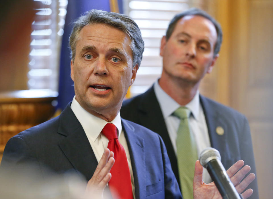 FILE - In this Aug. 8, 2018, file photo, Kansas Gov. Jeff Colyer, left, alongside Lt. Gov. Tracey Mann, addresses the media at the Kansas Statehouse in Topeka, Kan., a day after his primary race against Kansas Secretary of State Kris Kobach. Colyer conceded late Tuesday, Aug. 14, 2018, in the state's Republican gubernatorial primary, saying he will endorse Kobach a week after their neck-and-neck finish threatened to send the race to a recount. (Chris Neal/The Topeka Capital-Journal via AP, File)