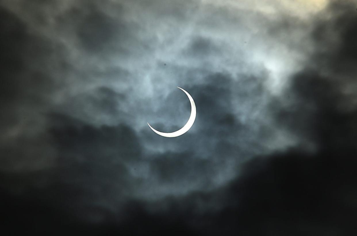 The annular eclipse of the sun pokes out through the clouds during a watch party at the Fleischmann Planetarium in Reno, Nevada on Oct. 14, 2023.
