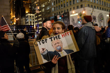 People hold signs at a protest against U.S. President-elect Donald Trump near Trump Tower in New York City, U.S. January 19, 2017. REUTERS/Stephanie Keith