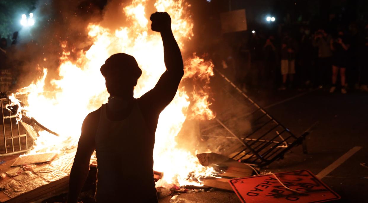 Demonstrators stand around a fire during a protest on May 31 near the White House in response to the killing of George Floyd. (Photo: Alex Wong via Getty Images)