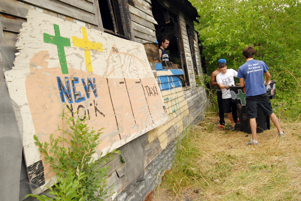 DETROIT, MI - JUNE 16: Volunteers help clean up abandoned homes as part of the Foster the People, Foster the Future: Do Good Project at Heidelberg Project on June 16, 2012 in Detroit, Michigan. (Photo by Paul Warner/Getty Images)