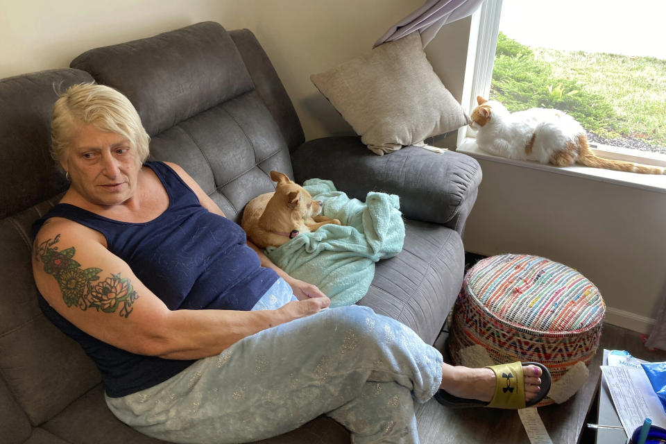 Janna Sharrett relaxes at home on a day off from her job as a full-time customer service rep for a contact lens and eyeglass company, on Tuesday, Nov. 1, 2022, in Grove City, Ohio. Sharrett earns $14.94 an hour but pays just $695 a month in rent thanks to the affordable housing apartment developed by a local nonprofit to expand the number of low-rent options in central Ohio. A shortage of housing of all kinds in the region is raising concerns as Intel Corp. develops a $20 billion project expected to add thousands of new residents. (AP Photo/Andrew Welsh-Huggins)