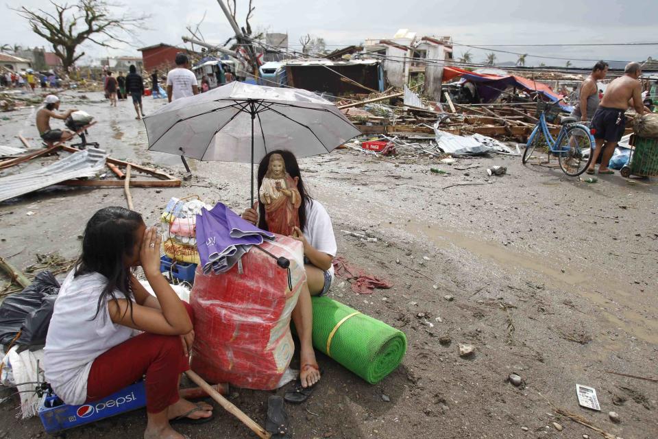 A survivor holds a statue of Jesus Christ, her only saved belonging, after a super Typhoon Haiyan battered Tacloban city, central Philippines November 9, 2013. Typhoon Haiyan, the strongest typhoon in the world this year and possibly the most powerful ever to hit land battered the central Philippines on Friday, forcing millions of people to flee to safer ground, cutting power lines and blowing apart houses. Haiyan, a category-5 super typhoon, bore down on the northern tip of Cebu Province, a popular tourist destination with the country's second-largest city, after lashing the islands of Leyte and Samar with 275 kph (170 mph) wind gusts and 5-6 meter (15-19 ft) waves. REUTERS/Romeo Ranoco (PHILIPPINES - Tags: DISASTER ENVIRONMENT RELIGION TPX IMAGES OF THE DAY)