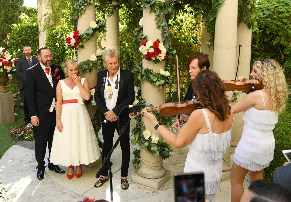 LAS VEGAS, NEVADA - OCTOBER 02: (EXCLUSIVE COVERAGE)  Sir Rod Stewart (R) sings during the wedding of Sharon Cook (C) and Andrew Aitchison (L) from Liverpool, England. The wedding was nearly cancelled due to the Thomas Cook Bankruptcy. Caesars Palace and Delta Air Lines flew the couple and their guests to Las Vegas as originally planned. The Wedding took place at Caesars Palace on October 02, 2019 in Las Vegas, Nevada. (Photo by Denise Truscello/WireImage)