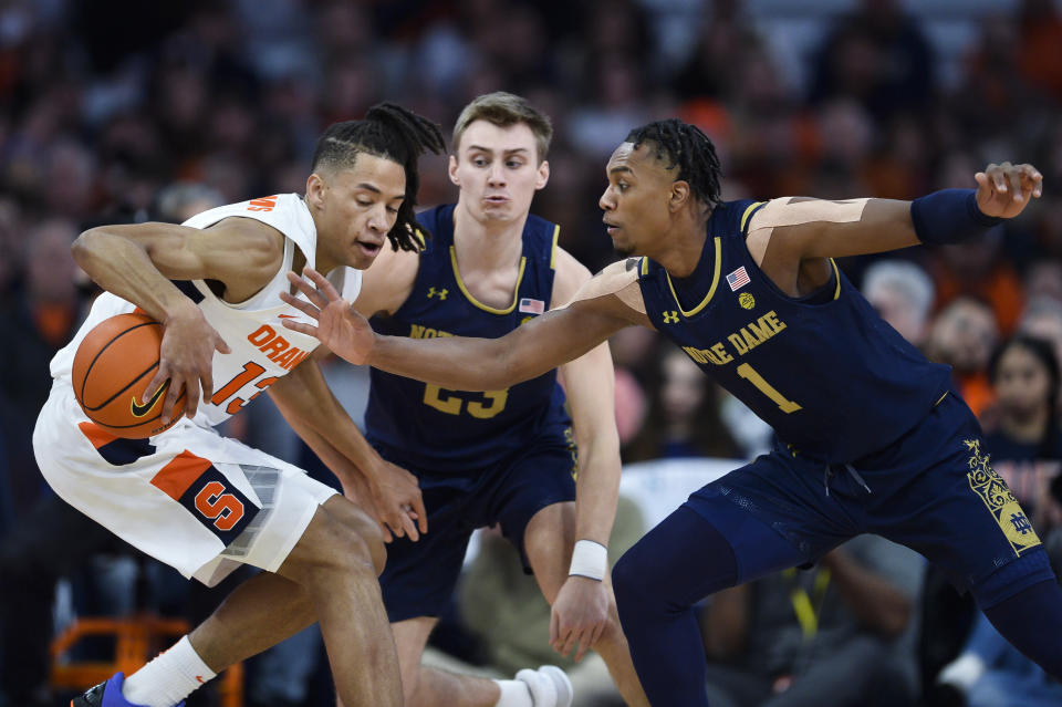 Syracuse forward Benny Williams, left, shields the ball from Notre Dame guard JJ Starling during the first half of an NCAA college basketball game in Syracuse, N.Y., Saturday, Jan. 14, 2023. (AP Photo/Adrian Kraus)