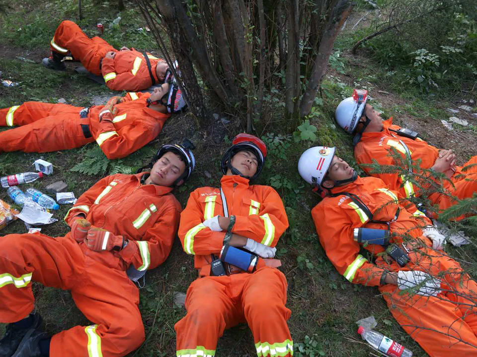 <p>Chinese paramilitary police sleep on the ground after an 18-hour rescue operation in Jiuzhaigou in China’s southwestern Sichuan province on Aug. 9, 2017. (Photo: STR/AFP/Getty Images) </p>