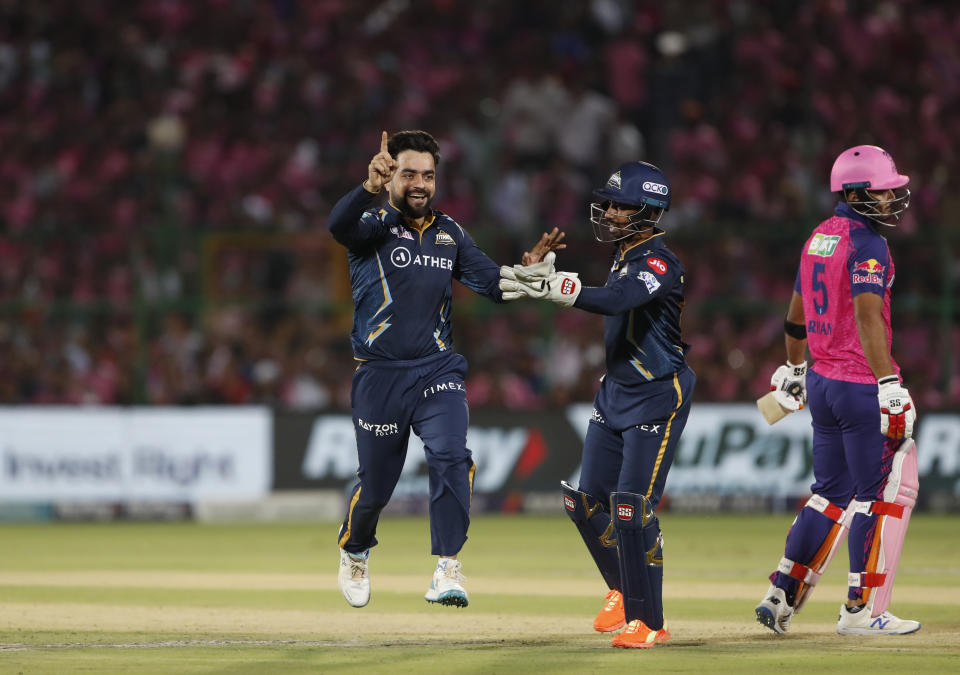 Gujarat Titans' Rashid Khan celebrates the dismissal of Rajasthan Royals' Riyan Parag, right, during the Indian Premier League (IPL)cricket match between Rajasthan Royals and Gujarat Titans in Jaipur, India, Friday, May 5, 2023. (AP Photo/Surjeet Yadav)