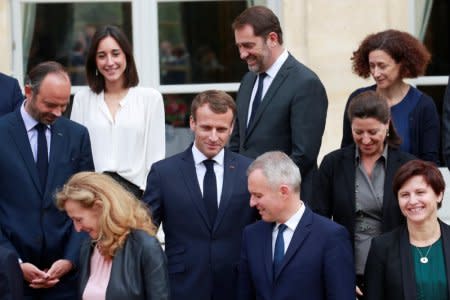 French President Emmanuel Macron is surrounded by French Prime Minister Edouard Philippe and members of his government as they pose for a family photo after the weekly cabinet meeting at the Elysee Palace in Paris, France, October 17, 2018.  REUTERS/Gonzalo Fuentes