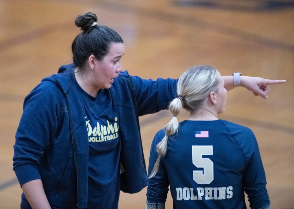 Dolphins head coach Jasmine King talks with Addisyn Tolbert (5) during the Gulf Breeze vs Navarre volleyball match at Navarre High School on Tuesday, Sept. 12, 2023.