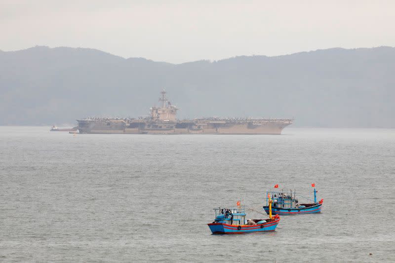 FILE PHOTO: The USS Theodore Roosevelt (CVN-71) is seen near Vietnamese fishing boats at a port in Da Nang city