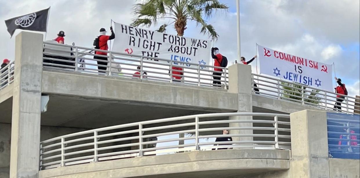 A white supremacist group gathered in February 2023 on the pedestrian bridge leading to Daytona International Speedway holding antisemitic banners.