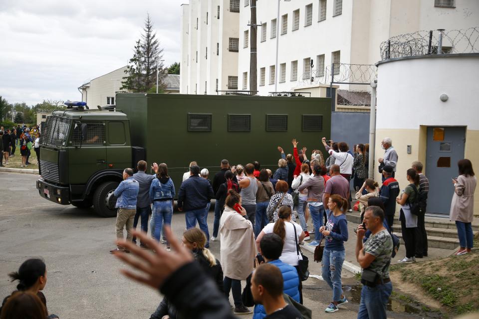 Friends and relatives of those detained during mass rally following presidential election gather at a detention center as a police bus drives out of the gate in Minsk, Belarus, Wednesday, Aug. 12, 2020. Belarus officials say police detained over 1,000 people during the latest protests against the results of the country's presidential election. (AP Photo)