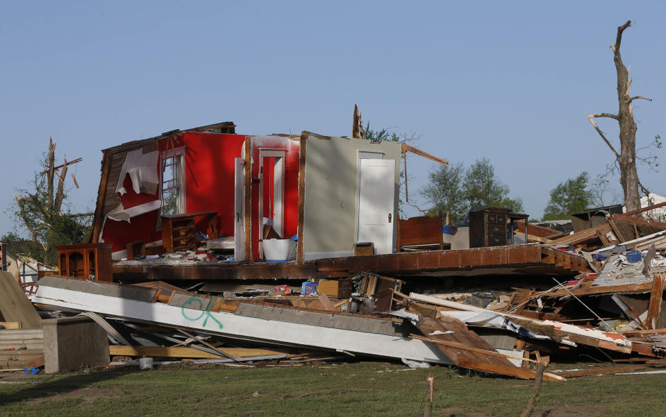 The remains of a home damaged by a tornado Sunday evening stands in Baxter Springs, Kan., Monday, April 28, 2014. The tornado left a trail of shattered homes, twisted metal and hanging power lines. One person died, but it was not clear whether the death was related to the storm. Volunteers were meeting early Monday to discuss cleanup efforts. Emergency officials say 60 to 70 homes and 20 to 25 businesses were destroyed or damaged in the town. (AP Photo/Orlin Wagner)