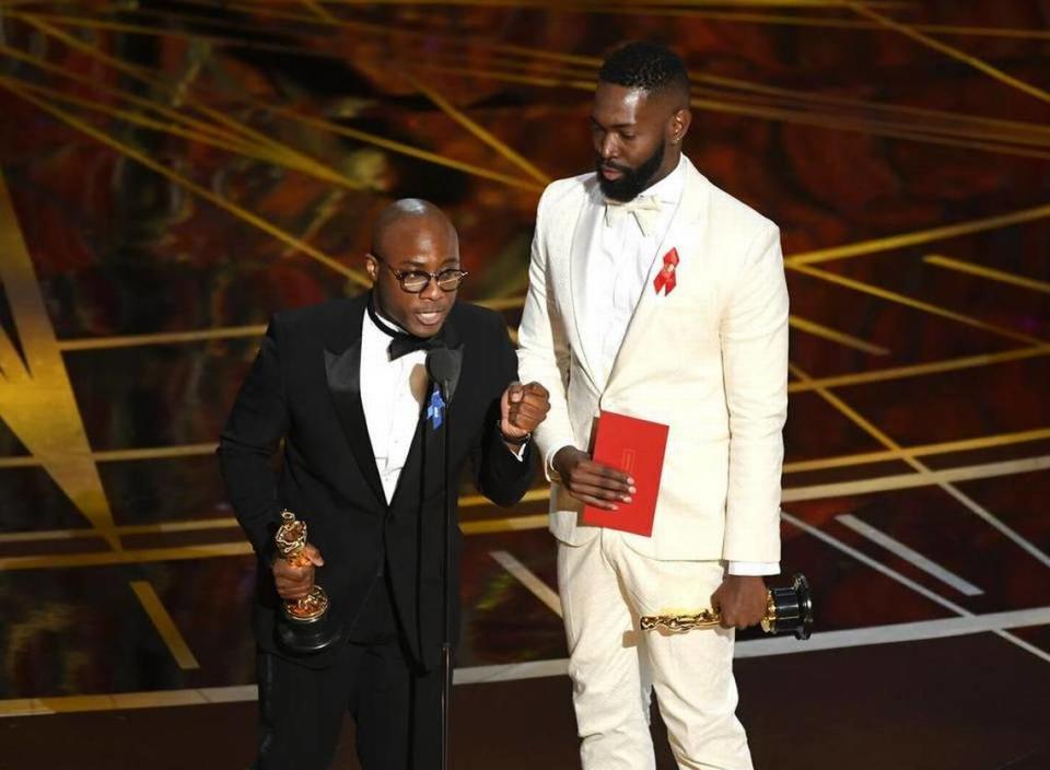 El guionista y director Barry Jenkins (a la izquierda) y el guionista Tarell Alvin McCraney (a la derecha) aceptando el premio al Mejor Guion Adaptado por "Moonlight" en el escenario durante la 89 edición de los Premios de la Academia en Hollywood and Highland Center el 26 de febrero de 2017 en Hollywood, California.