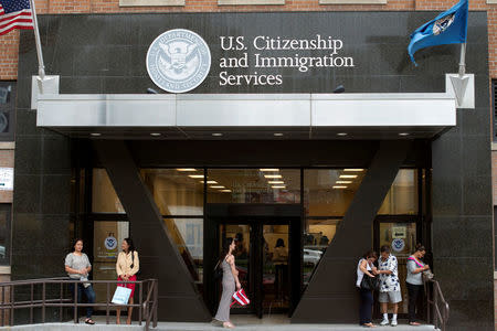 FILE PHOTO - People stand on the steps of the U.S. Citizenship and Immigration Services offices in New York, U.S. on August 15, 2012. REUTERS/Keith Bedford/File Photo