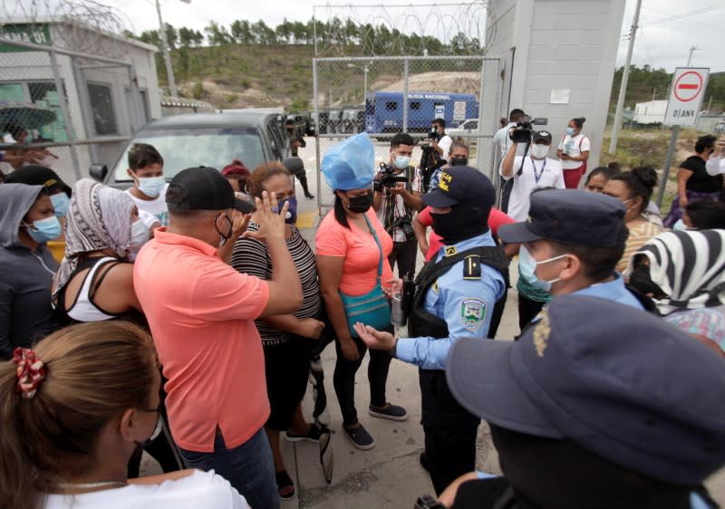 Familiares de reclusos en la prisión de alta seguridad La Tolva, en Honduras, hablan con la policía durante las peleas entre los miembros encarcelados de Barrio 18 y la pandilla rival MS-13, en Moroceli