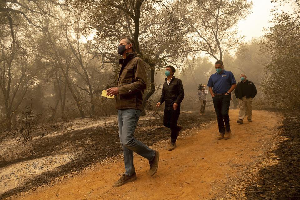 Gov. Gavin Newsom takes notes as he tours the North Complex Fire zone with California Secretary for Environmental Protection Jared Blumenfeld, second left, and California Secretary for Natural Resources Wade Crowfoot in Butte County on Friday, Sept. 11, 2020, outside of Oroville, Calif. (Paul Kitagaki Jr./The Sacramento Bee via AP, Pool)