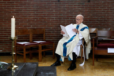 Father Jacques Clemens reads at a mass at St. Benoit church in Nalinnes, Belgium, July 10, 2016. REUTERS/Francois Lenoir