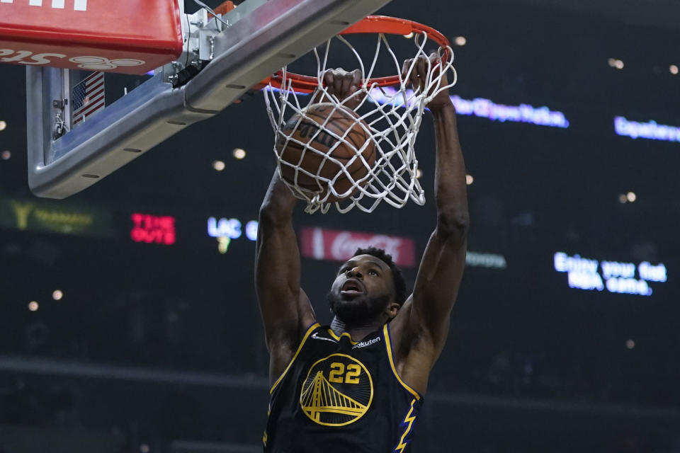 Golden State Warriors forward Andrew Wiggins (22) dunks the ball during the first half of an NBA basketball game against the Los Angeles Clippers in Los Angeles, Sunday, Nov. 28, 2021. (AP Photo/Ashley Landis)