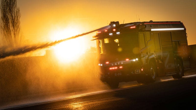 A photo of LA's new Rosenbauer truck spraying water at sunset. 