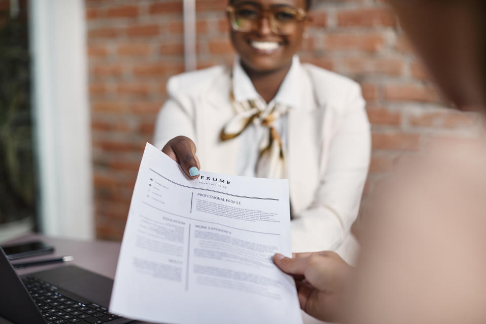 Woman handing an interviewer her résumé