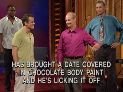 Wayne, Chip, and Ryan all stand around Colin, with onscreen text reading, "He has brought a date covered in chocolate body paint and he's licking it off"