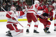 Detroit Red Wings goaltender Alex Nedeljkovic (39) gloves a shot while defenseman Gustav Lindstrom (28) guards Carolina Hurricanes center Seth Jarvis (24) during the second period of an NHL hockey game Thursday, April 14, 2022, in Raleigh, N.C. (AP Photo/Chris Seward)