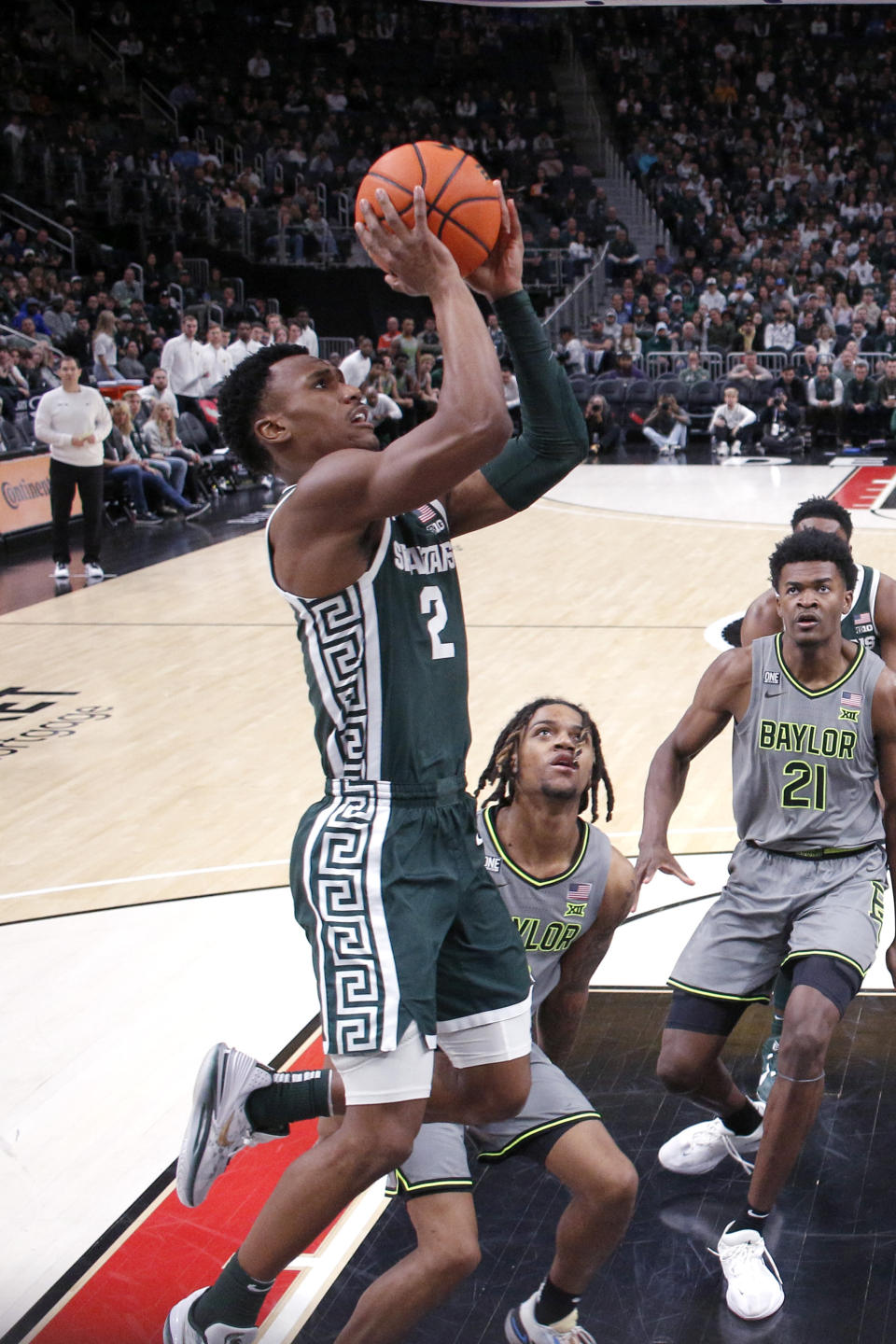 Michigan State guard Tyson Walker (2) goes up for a shot against Baylor center Yves Missi (21) and Baylor guard Jayden Nunn during the second half of an NCAA college basketball game, Saturday, Dec. 16, 2023, in Detroit. Michigan State won 88-64. (AP Photo/Al Goldis)