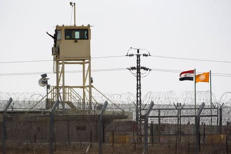 A member of Egypt's security forces gestures as he stands on a watchtower in North Sinai as seen from across the border in southern Israel July 2, 2015. REUTERS/Amir Cohen