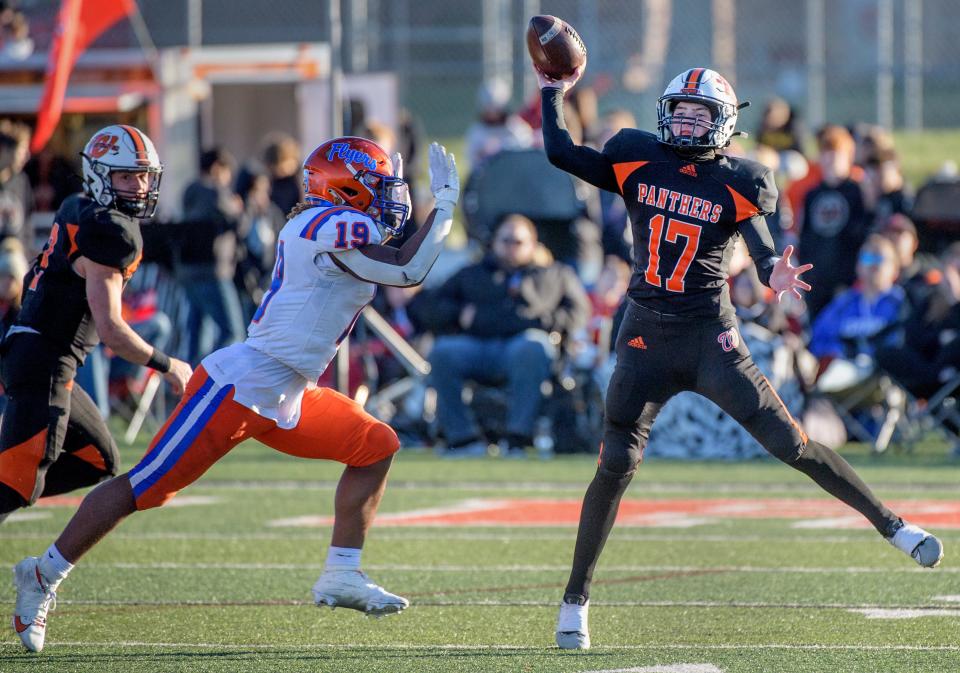 Washington's Masyn Burke (17) throws a pass under pressure from East St. Louis' Elmo Gilliam Jr. late in the second half of their Class 6A football state semifinals Saturday, Nov. 18, 2023 at Babcook Field in Washington.