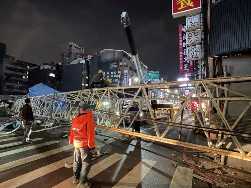 台南市中西區一處新建工地旁道路6日突傳路面塌陷，一輛小貨車掉落坑洞內，建設公司出動吊車欲吊起坑洞中小貨車，卻又疑因地基不堪負荷導致吊車傾斜，吊臂更是直接砸向路面，橫跨西門路段。（中央社）