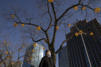 In this photo taken Saturday, Feb. 22, 2020, a resident walks on the quiet street of Beijing, China. Regulators on Monday promised tax cuts and other aid to help companies recover from China's virus outbreak and expressed confidence the ruling Communist Party's growth targets can be achieved despite anti-disease controls that shut down much of the economy. (AP Photo/Ng Han Guan)