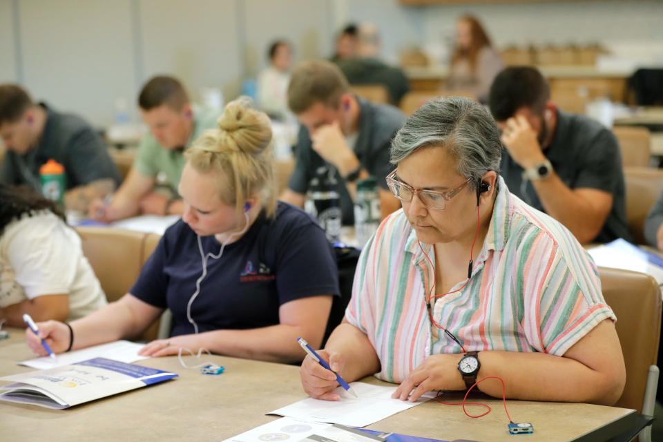 Hannah Meyer, a registered nurse at Ascension NE Wisconsin-St. Elizabeth Campus, left, and Quincey Davidson, a crisis advocate at Pillars, participate in Crisis Intervention Partner training at Catalpa Health on July 26 in Appleton. During the training, participants listen to simulated auditory hallucinations that help them understand the challenges faced by people with serious persistent mentall illness and develop empathy.